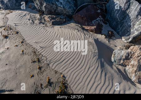 Détails intéressants sur le motif de sable au coucher du soleil sur la plage de Zuma à Malibu, en Californie Banque D'Images
