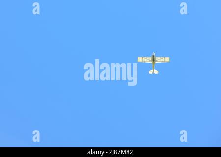 Un petit avion se déforme dans un ciel bleu vide Banque D'Images