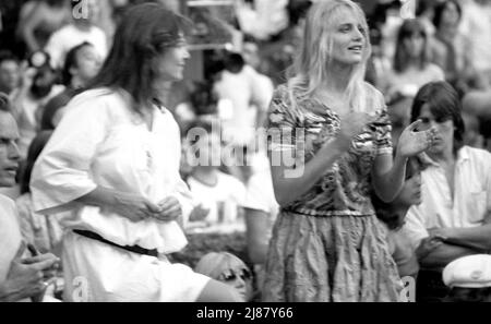 Une jeune Daryl Hannah regarde son petit ami Jackson Browne au concert antinuclear au Hollywood Bowl, vers 1981, Los Angeles, CA. Banque D'Images