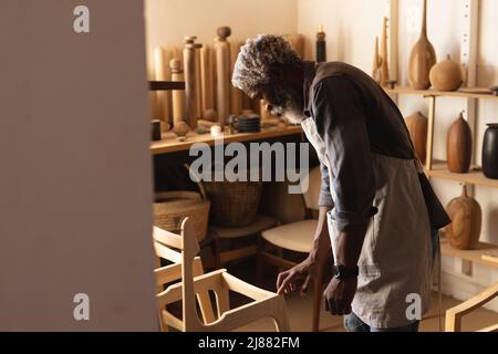 Vue latérale du menuisier afro-américain de fabrication de meubles dans l'atelier Banque D'Images