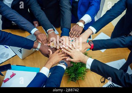 vue de dessus de travail d'équipe haut cinq un groupe de succès afro-américains, européens, arabe et coréen homme d'affaires et femme d'affaires travaillant Banque D'Images