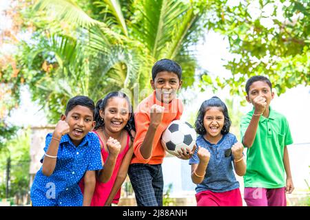 groupe d'adolescents avec le football criant en regardant la caméra - conecept de l'excitation, du divertissement et de la compétition Banque D'Images