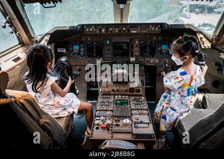 Samut Prakan, Thaïlande. 14 mai 2022. Les enfants jouent un pilote dans le poste de pilotage d'un ancien Boeing 747 qui a été converti en café. Matt Hunt / Neato. Credit: Matt Hunt / Neato / Alay Live News Banque D'Images