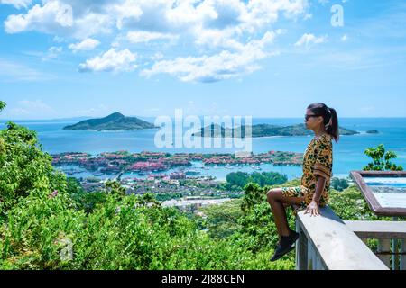 Point de vue sur la baie de Mahé à l'île Eden, Mahé Seychelles, une plage tropicale avec des palmiers, et un océan bleu à Mahé Seychelles. Femme au point de vue Banque D'Images