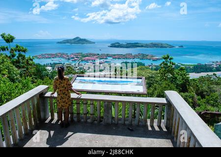 Point de vue sur la baie de Mahé à l'île Eden, Mahé Seychelles, une plage tropicale avec des palmiers, et un océan bleu à Mahé Seychelles. Femme au point de vue Banque D'Images