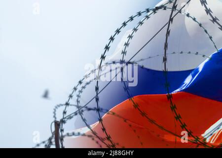 Drapeau de la Russie sur fond de barbelés. La loi martiale en Ukraine. Arrêter la guerre et la paix en Ukraine Banque D'Images