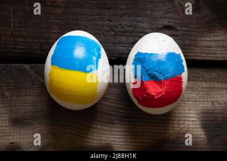 Deux oeufs de poulet, l'un avec le drapeau de la Russie est cassé et le second avec le drapeau de l'Ukraine est entier, la Russie a perdu la guerre, le pastica et la culture 2022 Banque D'Images