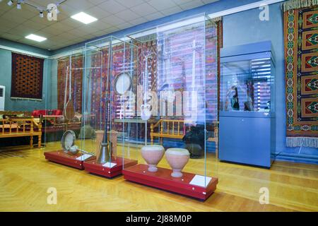 Une salle avec des instruments de musique et des tapis suspendus. Au Musée des arts appliqués de Tachkent, Ouzbékistan. Banque D'Images