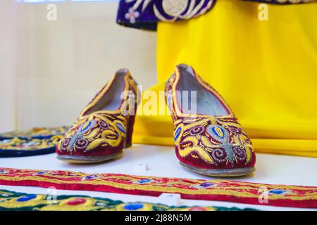 Chaussures pour femme recouvertes d'une broderie traditionnelle colorée et riche. Au Musée des arts appliqués de Tachkent, Ouzbékistan. Banque D'Images