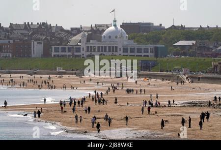 Les gens marchent sur la plage de Whitley Bay sous le dôme du centre de loisirs et de restauration de la ville espagnole à North Tyneside, Tyne et Wear. Les températures s'échauffent pour le week-end, car la plupart des Britanniques peuvent s'attendre à être baignés de soleil. Cependant, le Bureau met a averti qu'un samedi ensoleillé, qui serait idéal pour un barbecue, pourrait être suivi par de fortes pluies et des orages. Date de la photo: Samedi 14 mai 2022. Banque D'Images