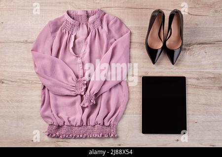 Chaussures avec blouse et tablette sur bureau en bois blanc. Plan d'étapage avec vue de dessus. Banque D'Images