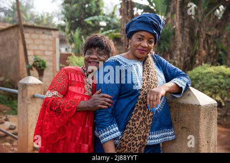 Deux femmes africaines matures se embrassent, elles sont vêtues de vêtements africains Banque D'Images