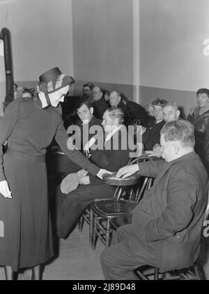 La réunion s'ouvre avec la collecte. L'armée contribue (environ un dollar et cinquante cents) de nouveau, ainsi que le public. Armée du salut, San Francisco, Californie. Banque D'Images