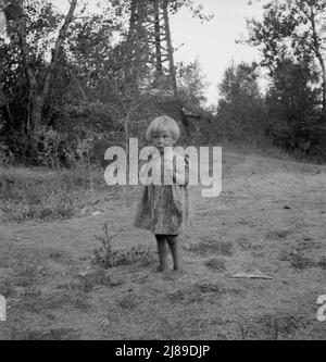 Enfant migrateur dans le camp de squatter avant l'ouverture de la saison du saut. Ses petits frères travaillent sur le terrain. Washington, vallée de Yakima. Banque D'Images