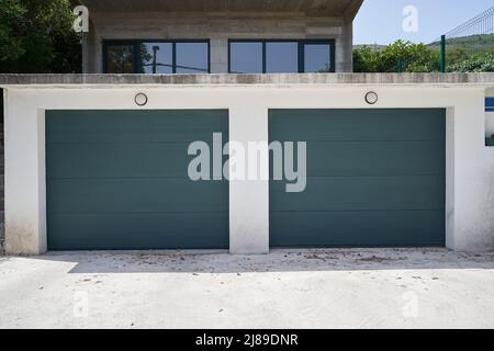 Façade d'un garage non nettoyé avec portes grises Banque D'Images