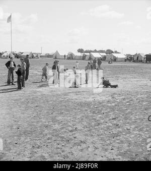 Temps de marbre dans le camp de travail migratoire de l'Administration de la sécurité agricole (AAS) (situation d'urgence.) Beaucoup d'espace pour jouer et beaucoup de compagnons pour les enfants pendant la récolte de pois. Près de Calipatria, Imperial Valley, Californie. Banque D'Images