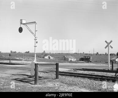 Les tentes des migrants sont une vue commune le long de l'droite de passage du Pacifique Sud. Près de Fresno, Californie. [Panneau: 'Chemin de fer Crossing']. Banque D'Images