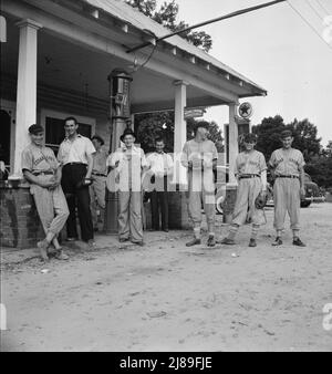 Le 4 juillet, près de Chapel Hill, en Caroline du Nord. Les stations de remplissage rurales deviennent des centres communautaires et des terrains de loafing généraux. Les hommes des combinaisons de baseball font partie d'une équipe locale qui jouera un match à proximité. Ils sont appelés l'équipe de Cedargrove. Banque D'Images