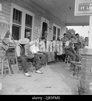 La station de remplissage rurale devient un centre communautaire et un terrain général pour le loafing. Les hommes en costume de baseball font partie d'une équipe locale qui jouera un match à proximité. L'équipe est appelée l'équipe de Cedargrove. Le 4 juillet, près de Chapel Hill, en Caroline du Nord. Banque D'Images