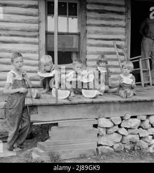 Les enfants de Millworker mangent de la pastèque sur le porche de la maison louée. 10 kilomètres au nord de Roxboro, Person County, Caroline du Nord. Banque D'Images