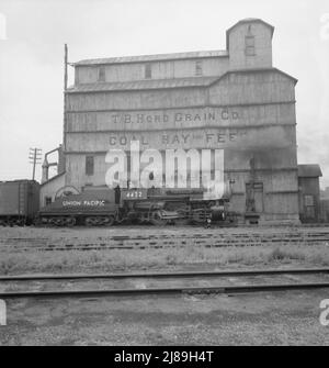 Élévateur de grain le long de la cour de chemin de fer. North Platte, Nebraska. [Signe : 'T.B. Hord grain Co., foin et alimentation de charbon ». Locomotive à vapeur Union Pacific]. Banque D'Images