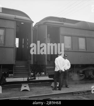 Gares ferroviaires, Kearney, Nebraska. Les passagers des trains terrestres reviennent à leur voiture après dix minutes d'arrêt de train entre San Francisco et Chicago. [Portiers noir Pullman et passager blanc]. Banque D'Images