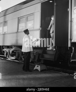 Gares ferroviaires, Kearney, Nebraska. Les passagers des trains terrestres reviennent à leur voiture après dix minutes d'arrêt de train entre San Francisco et Chicago. [Portier noir Pullman et passager blanc]. Banque D'Images