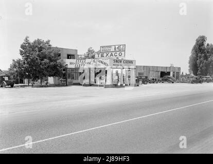 Près de Kingsburg. De petites stations-service indépendantes sont à la portée de l'autoroute. Californie. [Panneaux: 'Higher Octane; Fire-Chief essence; crème glacée, repas, boissons froides; Essence de l'Ouest; Texaco; huile pour moteur à neige Banque D'Images