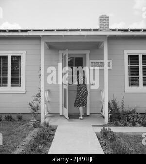 Tulare County, Farmersville, Californie. Camp de l'Administration de la sécurité agricole (FSA) pour les travailleurs agricoles migrateurs. Entrée à la clinique de l'Association médicale et de santé des travailleurs agricoles (AAS) pour l'aide de l'infirmière pour bébé malade. Une femme plus âgée dit : « Je suis juste un voisin et je me sens vraiment désolé pour eux ». Banque D'Images