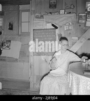 Mme Hull dans la maison du sous-sol d'une pièce (note tableau noir). "Je voulais un tableau noir pour longtemps pour mes versets bibliques, pour les garder dans notre esprit. Nous l'avons obtenu l'année dernière. » Dead Ox Flat, comté de Malheur, Oregon. ['chaque enfant est connu par ses doings, si son travail est pur, et si elle est correcte. Prov(erbs), 20:11']. Banque D'Images