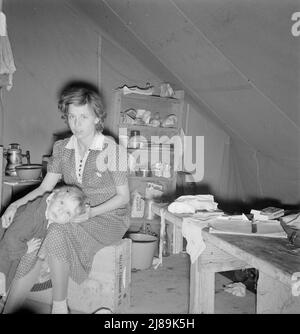 La jeune mère, âgée de vingt-deux ans, a une petite fille de trois ans. Merrill, Comté de Klamath, Oregon. Dans l'unité mobile du camp de la FSA (Administration de la sécurité agricole). Nouveau bébé attendu en décembre. Au cours de cette année, elle a travaillé avec son mari dans les domaines suivants : fraises (Helvetia, Oregon); cerises (Salem, Oregon); haricots (West Stayton, Oregon) ; houblon (Independence, Oregon). Est maintenant dans le camp des cueilleurs de pommes de terre à la fin de cette saison. « Nous n'avons pas de cent maintenant et nous avons perdu notre voiture parce que nous avons aidé certaines personnes. Il semble qu'il est pris chaque cent pour manger dehors, ça et voyager autour.". Banque D'Images