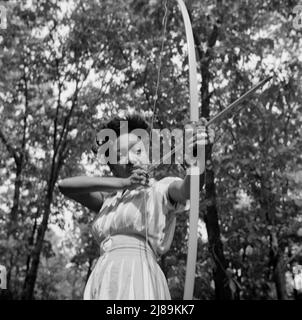 Bear Mountain, New York. Activités interraciales au Camp Fern Rock, où les enfants sont aidés par le Service des camps méthodistes. Loretta Gyles du Service de camp méthodiste tirant un arc. Banque D'Images