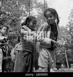 Bear Mountain, New York. Activités interraciales au Camp Fern Rock, où les enfants sont aidés par le Service des camps méthodistes. Les filles ajustant les sacs de chacun pour une randonnée. Banque D'Images