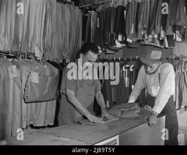 Washington, D.C. Un tailleur dans le nettoyage de Frank et l'établissement de pression modifiant une paire de pantalons pour un client. Banque D'Images