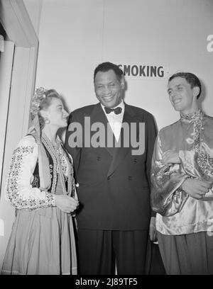 Washington, D.C., l'anniversaire de guerre de la Russie avantage au Watergate. Sonia Trembach, chanteuse à l'Orchestre Balalaika, et chef d'orchestre Paul Kovriga discutant avec Paul Robeson. Banque D'Images