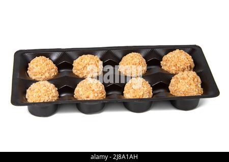 Boulettes de cachets d'arachide sucrées dans une boîte isolée sur fond blanc Banque D'Images