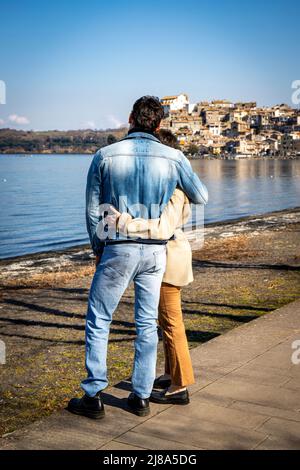 Un jeune couple embrasse sur la rive du lac Bracciano. Beau couple voyageant à Anguillara Sabazia en Latium, Italie. Atmosphère romantique et copie s Banque D'Images