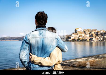 Un jeune couple embrasse sur la rive du lac Bracciano. Beau couple voyageant à Anguillara Sabazia en Latium, Italie. Atmosphère romantique et copie s Banque D'Images