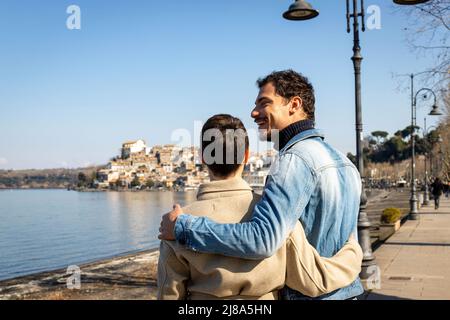 Un jeune couple embrasse sur la rive du lac Bracciano. Beau couple voyageant à Anguillara Sabazia en Latium, Italie. Atmosphère romantique et copie s Banque D'Images