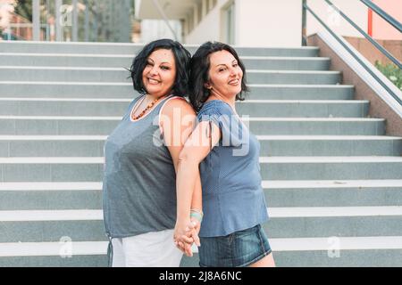 Portrait de deux sœurs jumelles brunette adultes. Différents styles Banque D'Images