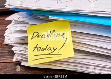 Note avec date limite d'écriture aujourd'hui sur la pile de papiers. Fichiers et journaux. Banque D'Images