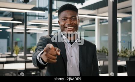 Homme multiracial américain homme d'affaires investisseur spécialiste financier de grande entreprise debout avec le sourire pointant l'index vers la caméra avec Hey Banque D'Images