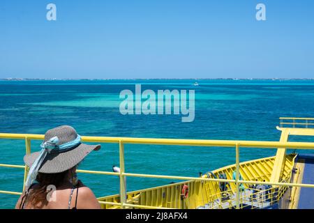 Une femme dans un chapeau de soleil observe la mer des Caraïbes à partir d'un navire de ferry au Mexique. Isla Mujeres. Banque D'Images