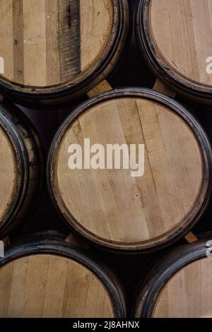 Fûts de whisky de chêne américain non étiquetés empilés les uns sur les autres à l'aide d'une cale en bois dans l'entrepôt de rackhouse de la distillerie Banque D'Images