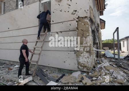 Kharkiv, Ukraine. 11th mai 2022. Les Neighboors entrent dans leur maison détruite pour voir s'ils peuvent sauver leur appartenance après qu'une artillerie ait endommagé le bâtiment et les sondages à Kharkiv, en Ukraine. Mercredi 11th mai 2022. L'invasion russe de l'Ukraine par ordre de Vladimir Poutine en février 2022 a produit de grands déplacements de personnes et une grande réaction de l'opinion publique et des forces politiques autour du monde les forces militaires russes sont entrées en territoire ukrainien le 24 février 2022. (Photo par Andoni Lubaki/Sipa USA) crédit: SIPA USA/Alay Live News Banque D'Images