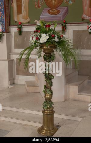 Belle exposition de fleurs ornementales dans une église chrétienne à Pâques en utilisant un support en laiton et blanc, rouge et vert comme thème Banque D'Images