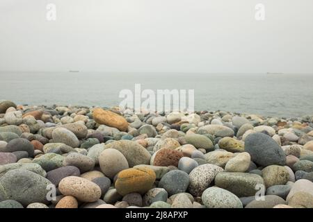 Des pierres de mer sur une plage. Une vue rapprochée des pierres polies arrondies Banque D'Images