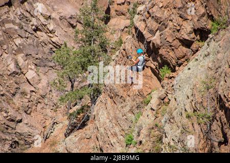 Femme tyrolienne dans une falaise dans les montagnes Rocheuses du Colorado Banque D'Images