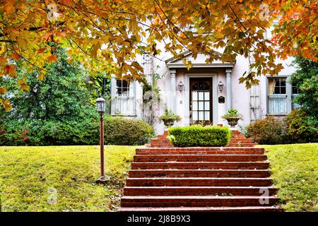 Appel de trottoir - charmante maison avec des marches en briques rouges et feuillage d'automne Banque D'Images