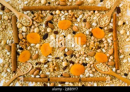 Ingrédients de puding traditionnels d'Ashura ou de Noah's Ark non cuits, cadre de fond avec cuillères en bois et bâtons de cannelle Banque D'Images